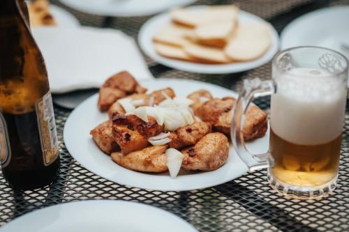 a plate of food on a table with a glass of beer at 5 Star Duluxe Apartment in Villa Magnetica in Ozurgetʼi