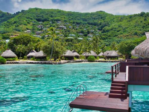a resort with a pool and huts on a mountain at Sofitel Kia Ora Moorea Beach Resort in Maharepa