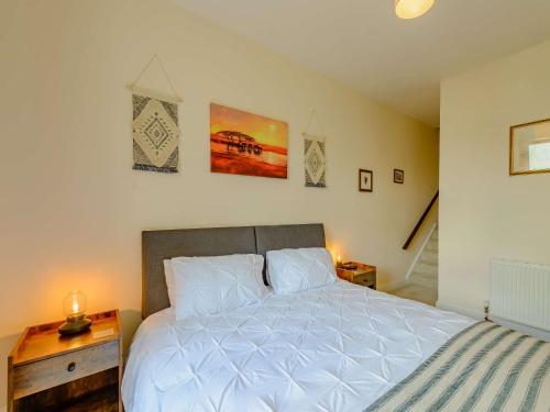 Un dormitorio con una gran cama blanca y una escalera. en 1 Bed in Eastbourne 88047, en Eastbourne
