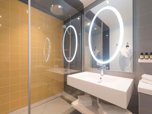 a bathroom with a sink and a mirror at Pullman Toulouse in Blagnac