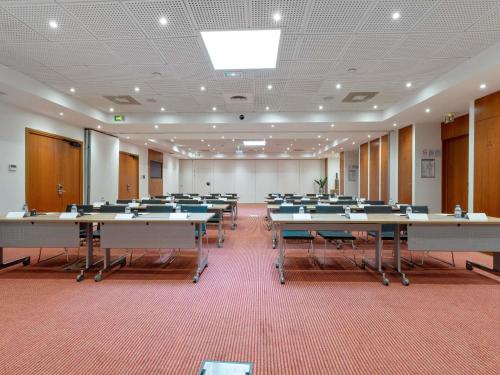 a large room with rows of tables and chairs at Pullman Toulouse in Blagnac