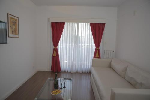 a living room with a white couch and red curtains at Pampa Plaza Hotel in Buenos Aires