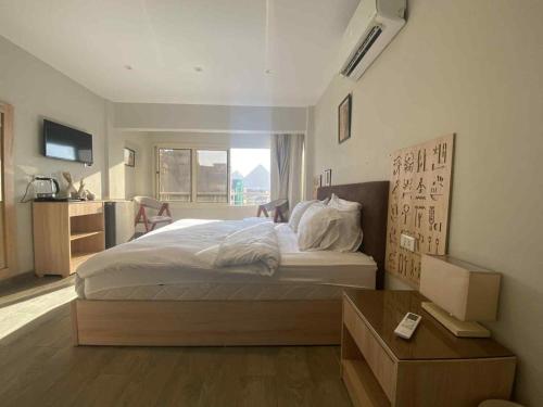 a bedroom with a large bed and a window at Zlato Pyramids View INN in Cairo