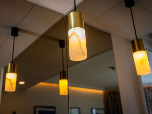 a group of lights hanging from a ceiling in a room at Mercure La Rochelle Vieux Port in La Rochelle