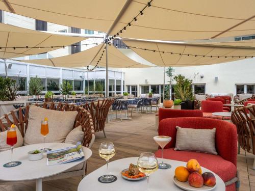 a restaurant with tables and chairs with wine glasses at Mercure La Rochelle Vieux Port in La Rochelle