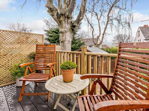 two chairs and a table on a deck with a tree at 1 bed in Ilkley 87569 in Ilkley