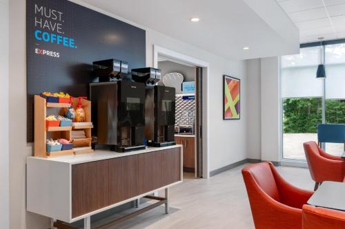 a coffee shop with two red chairs in a waiting room at Holiday Inn Express & Suites Pittsfield-Lenox-Berkshires by IHG in Pittsfield