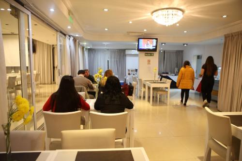 a group of people sitting at tables in a restaurant at Pampa Plaza Hotel in Buenos Aires