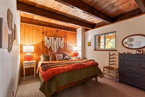 ein Schlafzimmer mit großem Bett und Holzdecke in der Unterkunft Retro Retreat, BBQ, Patio with Outdoor Seating! in Lake Arrowhead