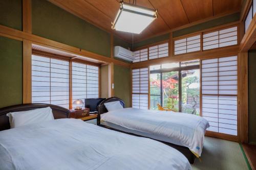 two beds in a room with windows in a room at -IRAKA- - Vacation STAY 19152 in Shiroishi