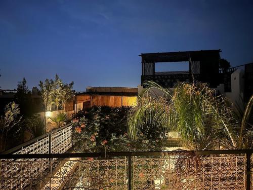 a fence with plants on it in a garden at night at Luxury riad with swimming pool breakfast included in Marrakech
