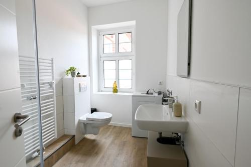 リューベックにあるCharmante 2-Zimmer-Wohnung am Wasser & Altstadtのトイレと洗面台を備えた白いバスルーム