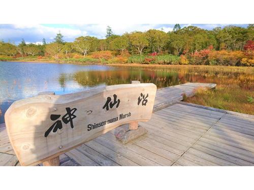 a wooden bench sitting on a dock next to a lake at Skye Niseko - Vacation STAY 70597v in Niseko