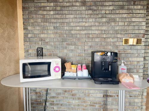 a microwave and a coffee maker on a table at Hotel Tetora Hachinohe - Vacation STAY 12756v in Hitoichi