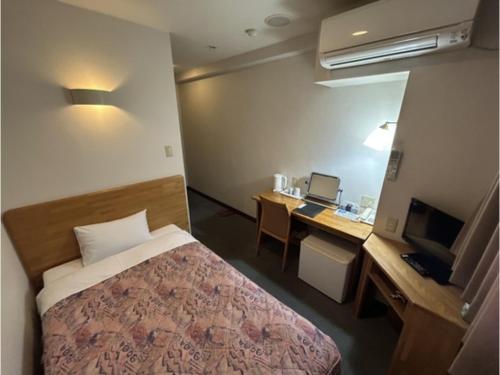 a room with a bed and a desk with a computer at Hotel Tetora Hachinohe - Vacation STAY 12733v in Hitoichi