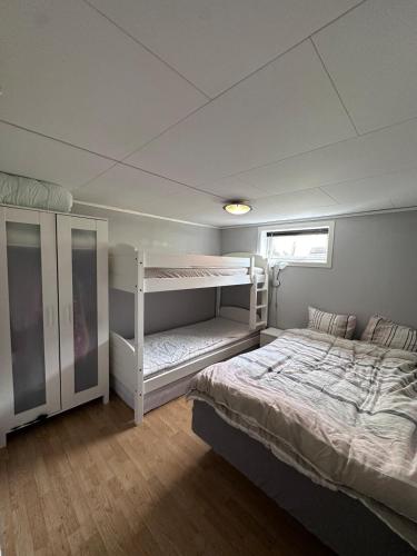 a bedroom with two bunk beds and a window at Basement apartment in beautiful Volda in Volda