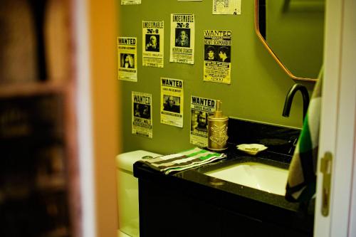 Un baño con lavabo e inodoro y carteles en la pared. en Apartamento Temático de Harry Potter, en São Paulo