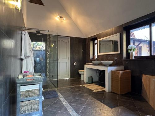 a bathroom with a glass shower and a sink at Sunset View in Rivière Noire