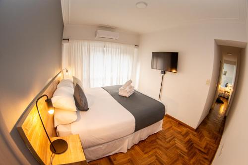 a hotel room with a large bed and a window at El Misti Suites Buenos Aires in Buenos Aires