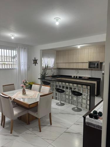 cocina con mesa y sillas y comedor en Casa em Guaratuba com piscina, en Guaratuba