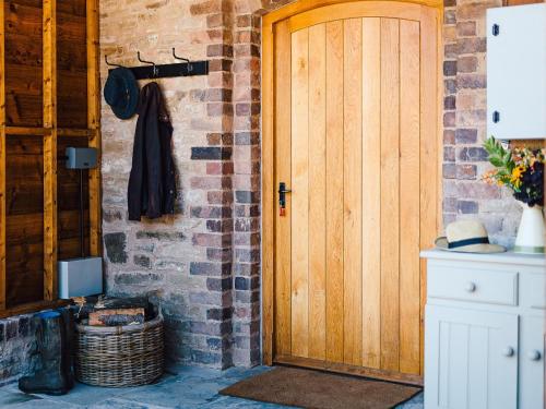 a wooden door in a brick wall with a basket at 4 Bed in Church Stretton 87695 in Cardington