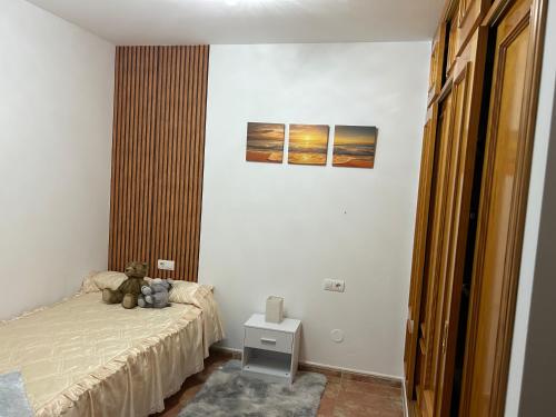 a bedroom with a teddy bear sitting on a bed at Casa Alegría in Cómpeta
