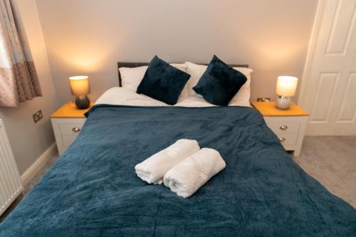 フリムリーにあるFrimley Sleeps 5 Free WiFi & Parkingのベッドとタオル2枚のある寝室