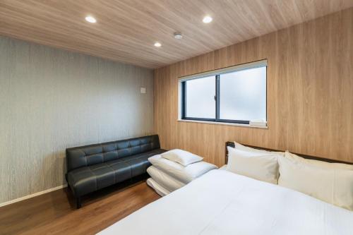 un dormitorio con una cama y un sofá en button - Vacation STAY 63542v, en Fukuoka