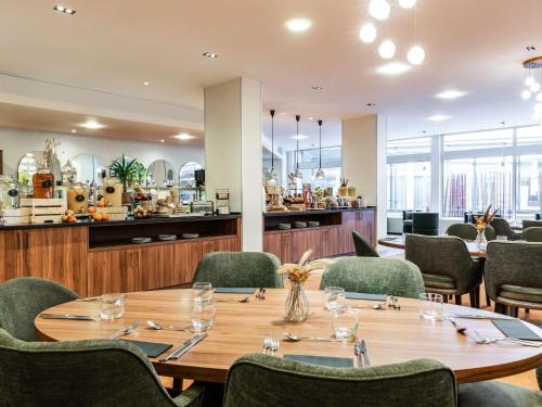 a dining room with a table and chairs at Mercure Paris CDG Airport & Convention in Roissy-en-France