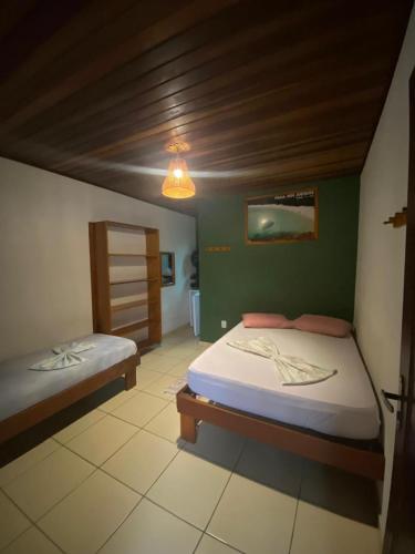 a bedroom with two beds and a green wall at Pousada Figueira in Trindade