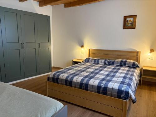 a bedroom with a bed with a blue and white plaid at Casa Sofia Panoramic View and Private Box in Temù