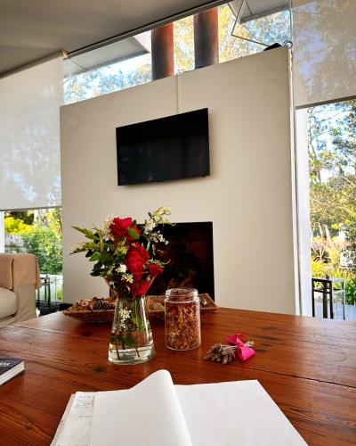 a vase of flowers on a table in a living room at Al Natural Posada in Nueva Palmira