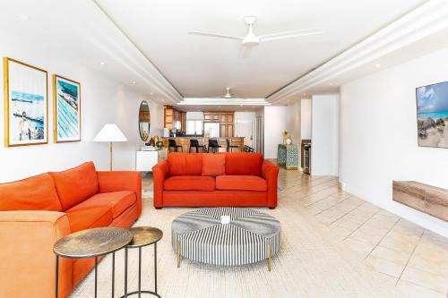 a living room with an orange couch and a table at 2 Bdrm Garden Marina View at The Yacht Club C4 in Providenciales