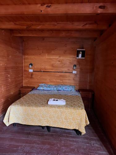 a bedroom with a bed in a wooden room at El Parador in Paso de la Patria
