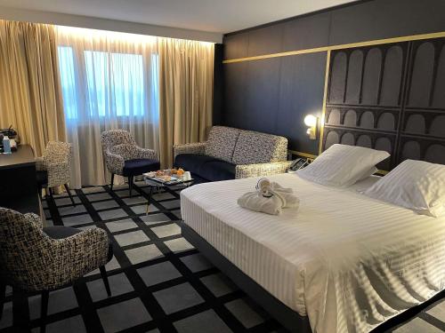 a hotel room with a bed and a desk and chairs at Mercure Orléans Centre Bords de Loire in Orléans