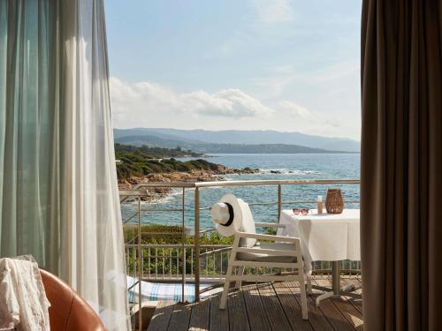 a balcony with a table and a view of the ocean at Sofitel Golfe d'Ajaccio Thalassa Sea & Spa in Ajaccio