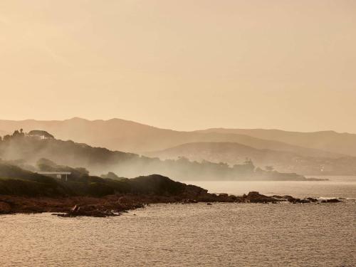 a view of a body of water with mountains in the background at Sofitel Golfe d'Ajaccio Thalassa Sea & Spa in Ajaccio