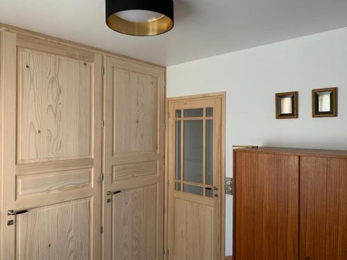 a room with two wooden closets and a door at Gîte du Château avec Piscine Intérieure in Ligny-le-Châtel