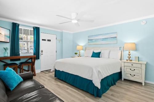 a blue bedroom with a bed and a desk at Parrot Beach Cottages Suite #1 in Bailey Hall