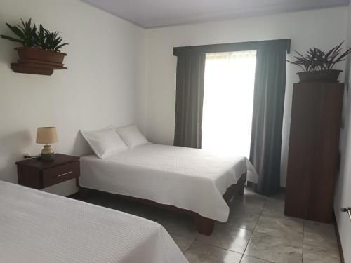a bedroom with two beds and a window at Paradise Experience Costa Rica in Pueblo Nuevo