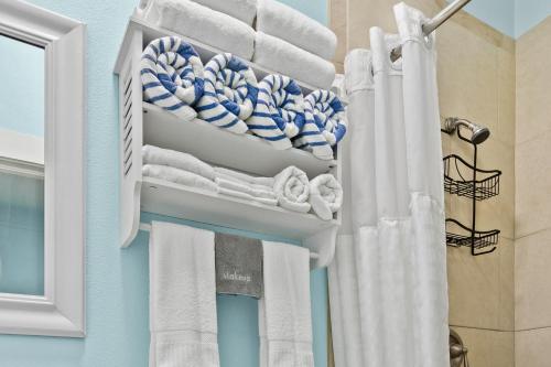 a bathroom with white towels and a shower curtain at Parrot Beach Cottages Suite #1 in Bailey Hall