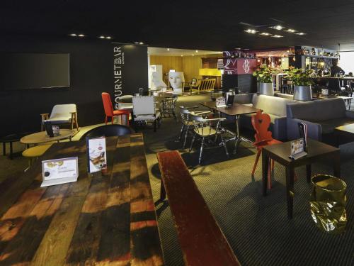 a restaurant with tables and chairs in a room at Novotel Metz Centre in Metz