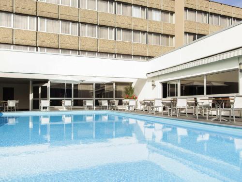 a large swimming pool in front of a building at Novotel Metz Centre in Metz