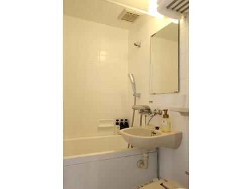 a bathroom with a sink and a bath tub at Smile Hotel Aomori - Vacation STAY 75492v in Aomori