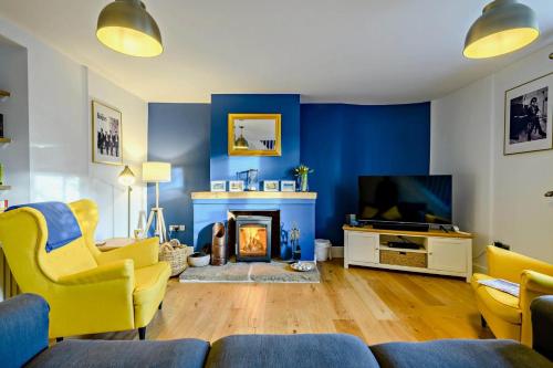 a living room with blue walls and a fireplace at Warborough House East in Kelling