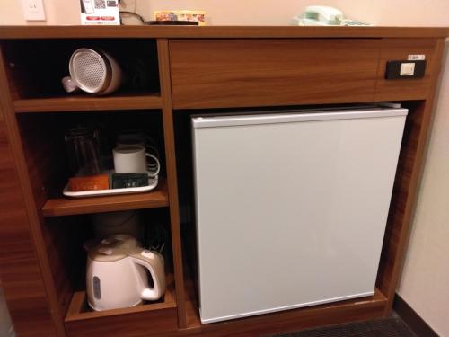 a cabinet with a white refrigerator in a kitchen at Smile Hotel Aomori - Vacation STAY 74797v in Aomori