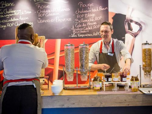 a man is standing behind a bar with a woman at ibis Montpellier Centre Comedie in Montpellier