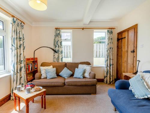 a living room with a couch and two windows at 2 bed property in Thurlestone WDELV in Thurlestone