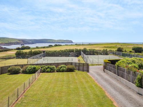 an empty yard with a fence and a tennis court at 2 bed property in Thurlestone WDELV in Thurlestone