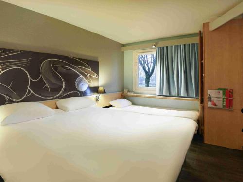 Ένα ή περισσότερα κρεβάτια σε δωμάτιο στο ibis Bourg en Bresse
